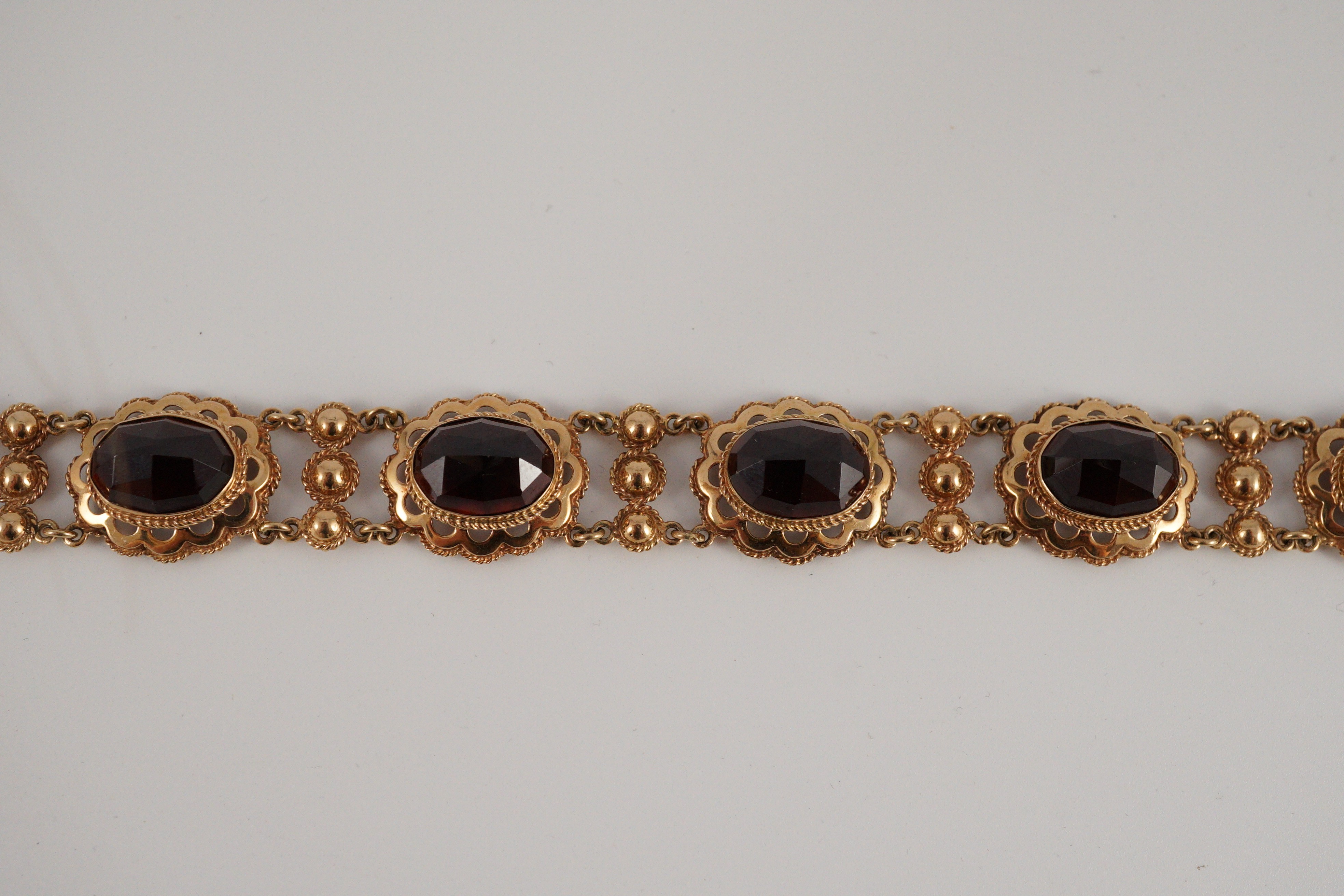 A 20th century Dutch 14k gold and six stone facet cut cabochon garnet set fancy link bracelet